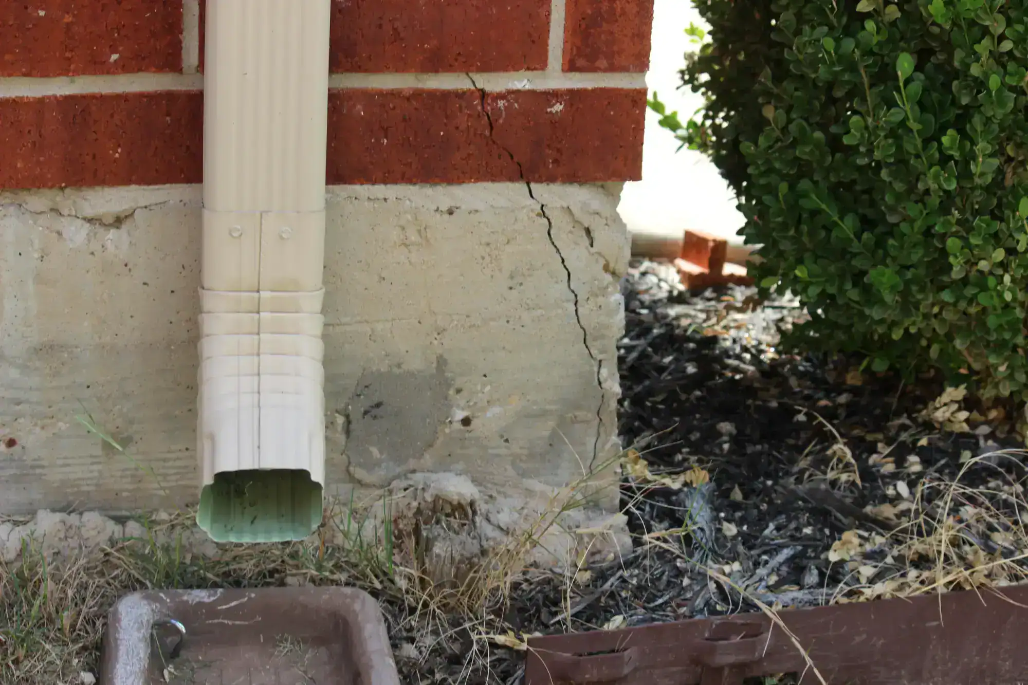 Cracked foundation drainpipe in Nassau County, New York, showing visible damage and wear, highlighting the need for professional waterproofing and masonry repairs by Diamond Masonry and Waterproofing.